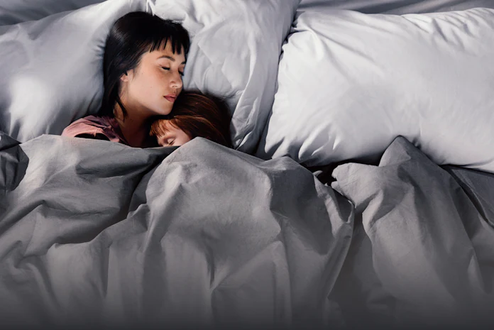 Mother and daughter snuggled in blankets