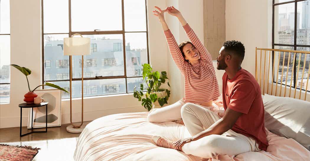Couple sitting and stretching on Casper mattress