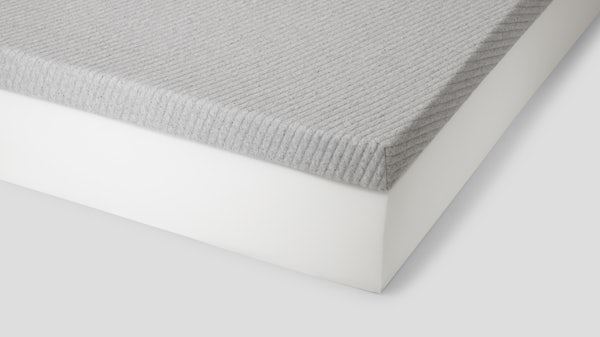 Corner of comfy topper on a foam mattress